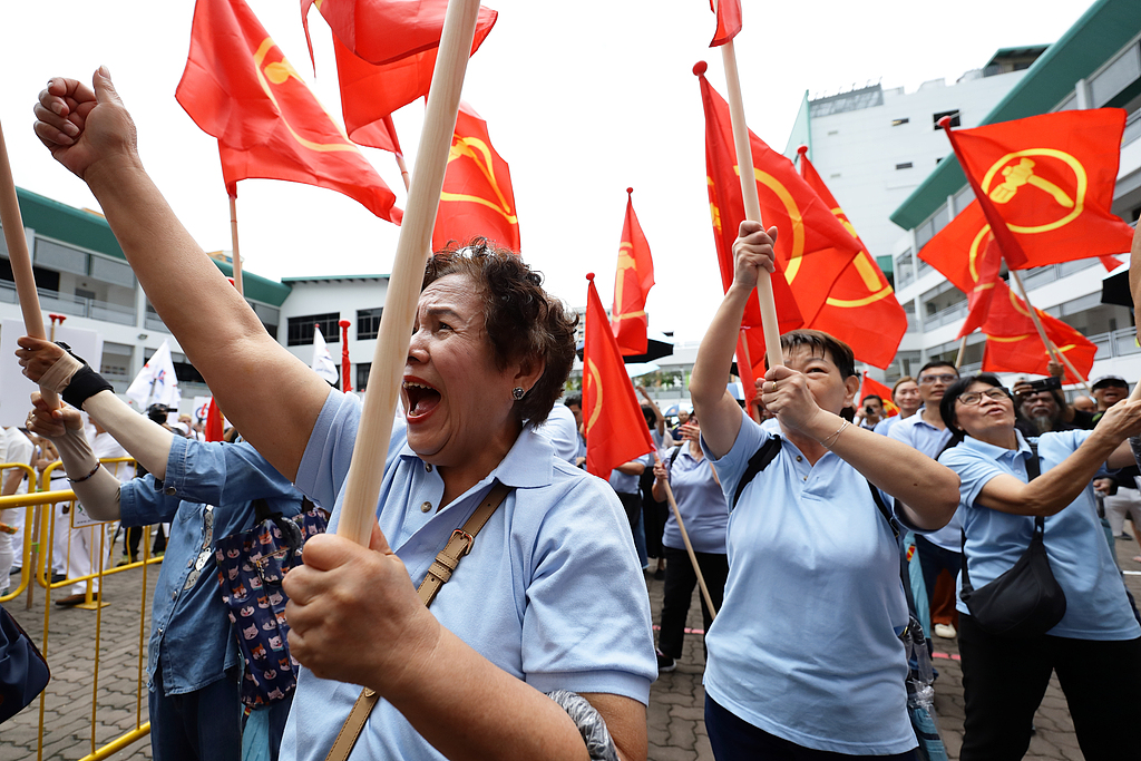Workers' Party supporters wave party flags as they cheer their candidates at the nomination center ahead of the general election in Singapore, April 23, 2025. /CFP