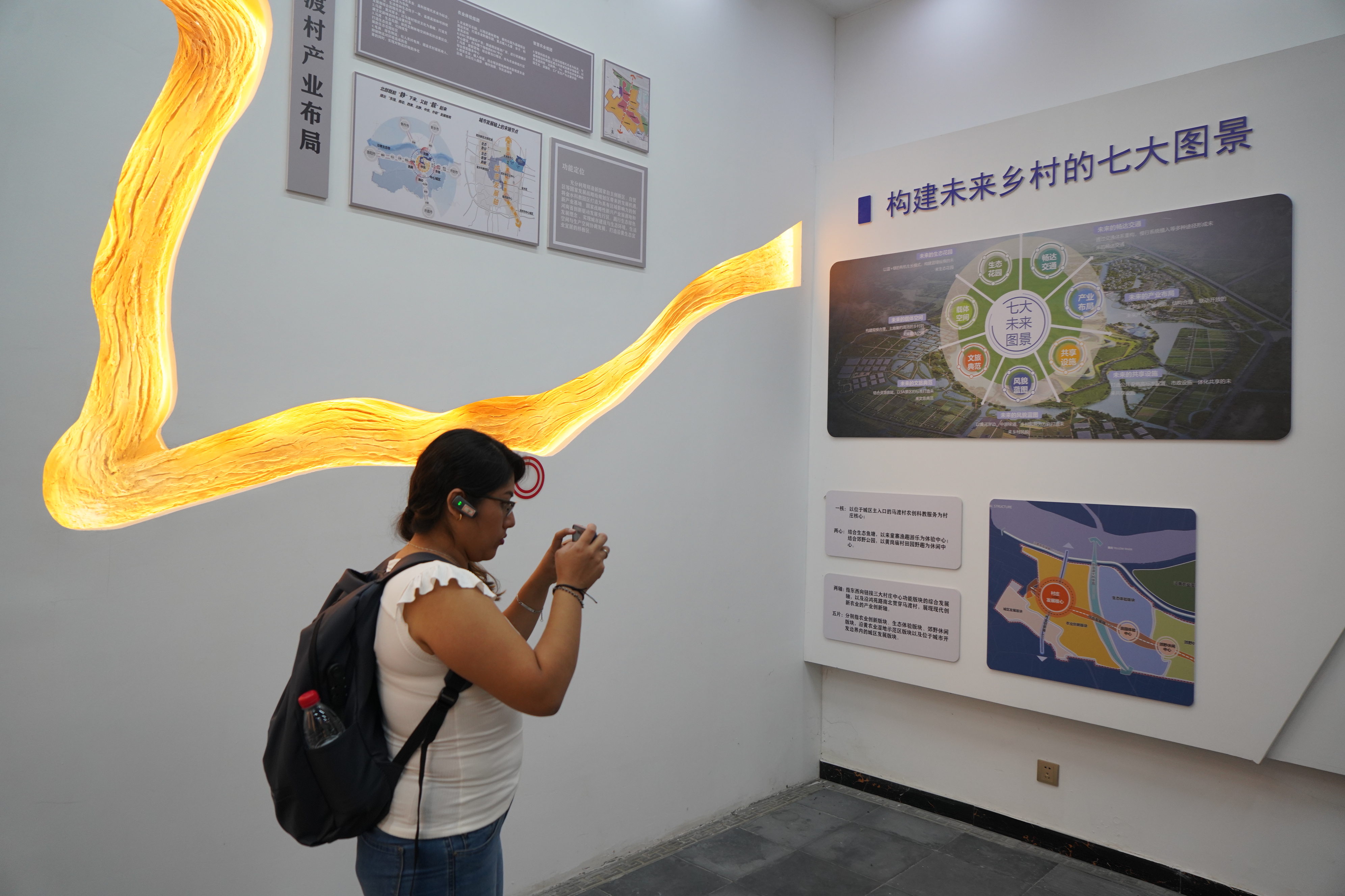 A member of a Latin American and Caribbean media delegation takes photos at the history museum of Madu Village in Zhengzhou, Henan Province on April 24, 2025. /CGTN