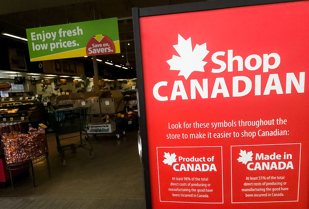 Close-up of a 'Shop Canadian' poster displayed in a storefront in Edmonton, Alberta, Canada, April 4, 2025. /VCG