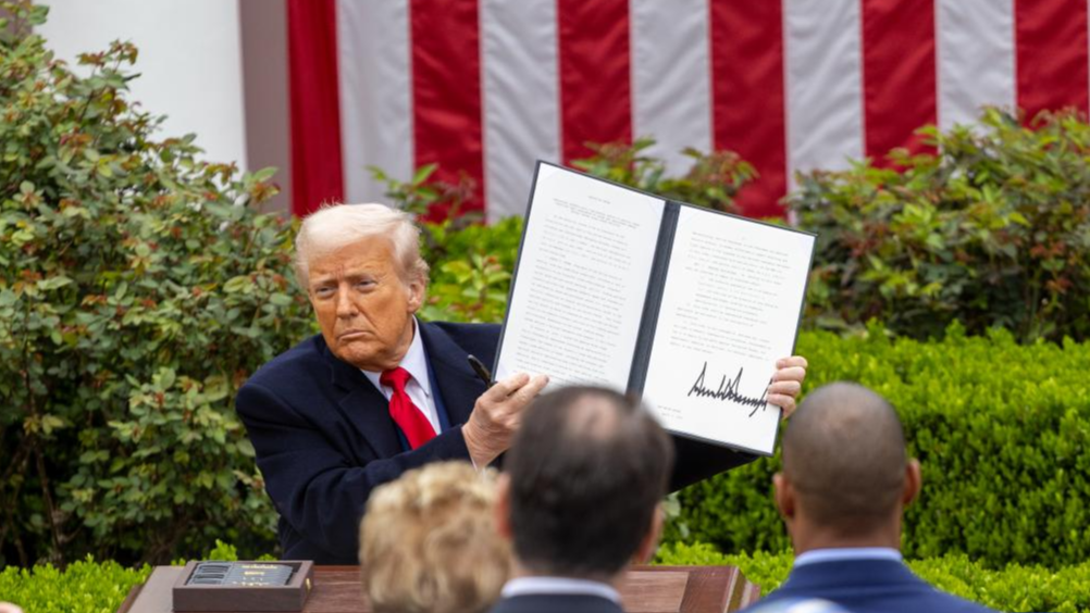 U.S. President Donald Trump shows an executive order on 