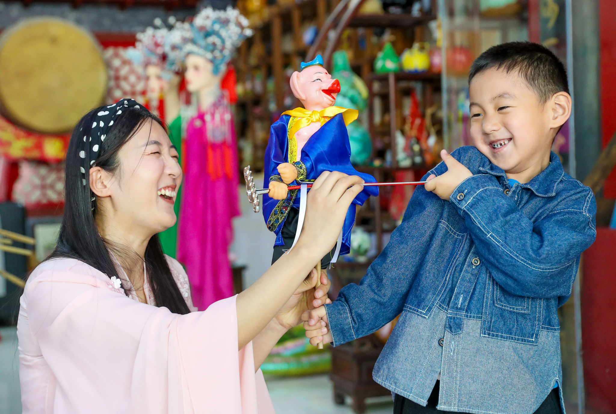 A performer from the Laixi puppet troupe interacts with a boy in Qingdao, Shandong Province on May 11, 2025. /VCG