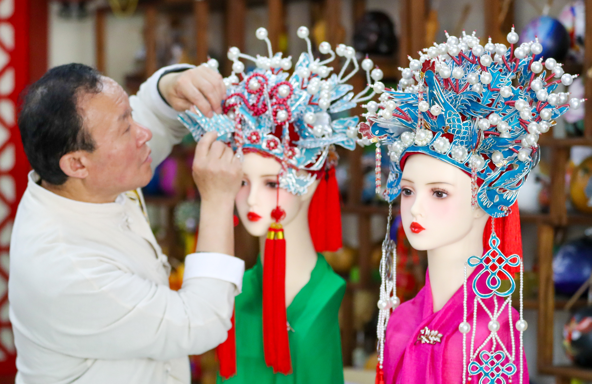 Laixi puppetry inheritor Jiang Yutao arranges the headdress of a puppet in Qingdao, Shandong Province, May 11, 2025. /VCG