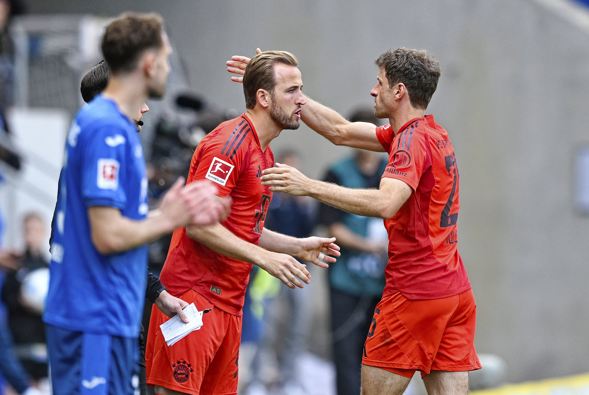 Harry Kane (C) and Thomas Müller (R) of Bayern Munich share a hug during their Bundesliga game against Hoffenheim at Rhein-Neckar-Arena in Sinsheim, Germany, May 17, 2025. /VCG