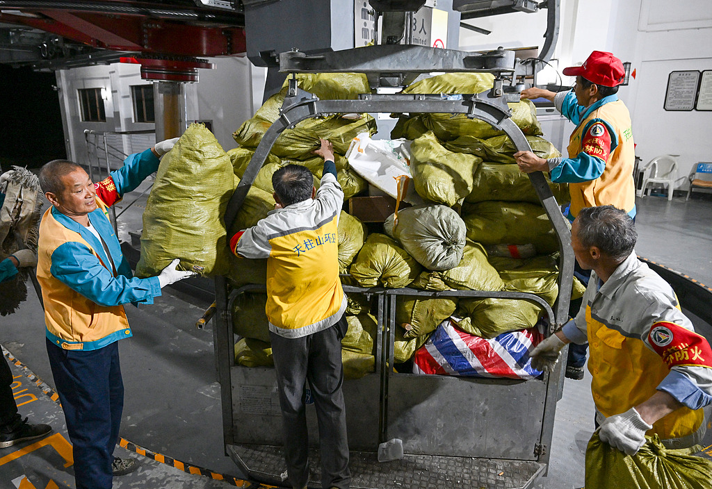 Sanitation workers unload sorted and packed waste from a special garbage truck at the foot of Tianzhu Mountain in Anqing, Anhui Province, on May 6. 2025. /VCG