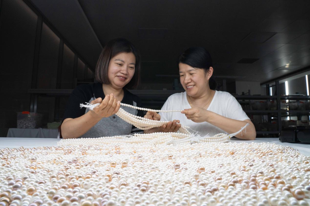 Workers inspect pearls at the processing factory in Deqing County, Zhejiang Province, China. /CGTN