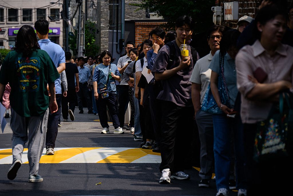 People queue up on a street outside a polling station to cast early votes for the presidential election in Seoul, South Korea, May 29, 2025. /CFP