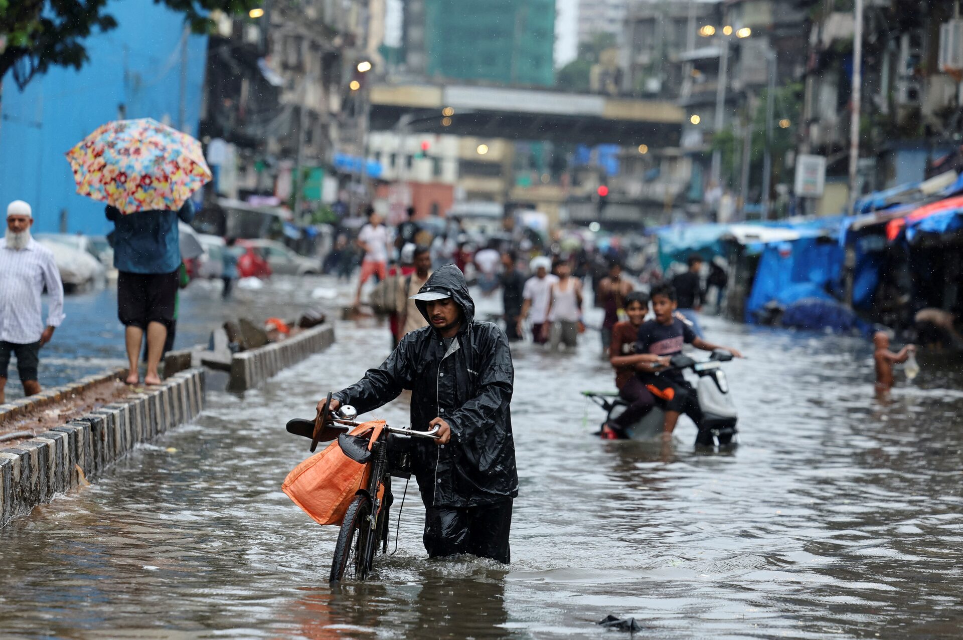 People wade through a waterlogged street following heavy rainfall in Mumbai, India, May 26, 2025. /Reuters