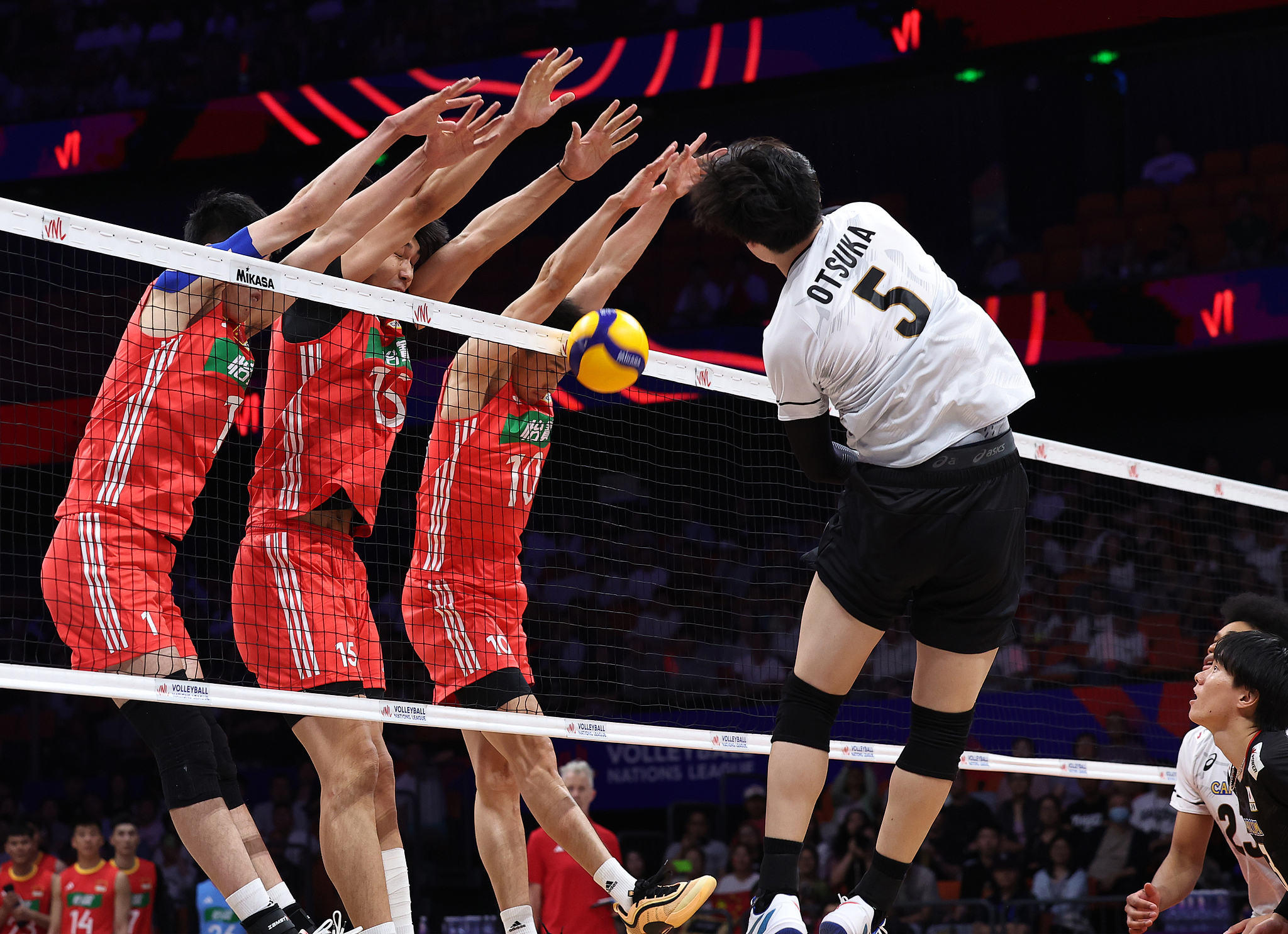 Wen Zihua (#1), Peng Shikun (#15), and Ji Daoshuai (#10) of China block a spike from Tatsunori Otsuka (#5) of Japan at the FIVB Men's Volleyball Nations League in Xi'an, northwest China's Shaanxi Province, June 11, 2025. /VCG
