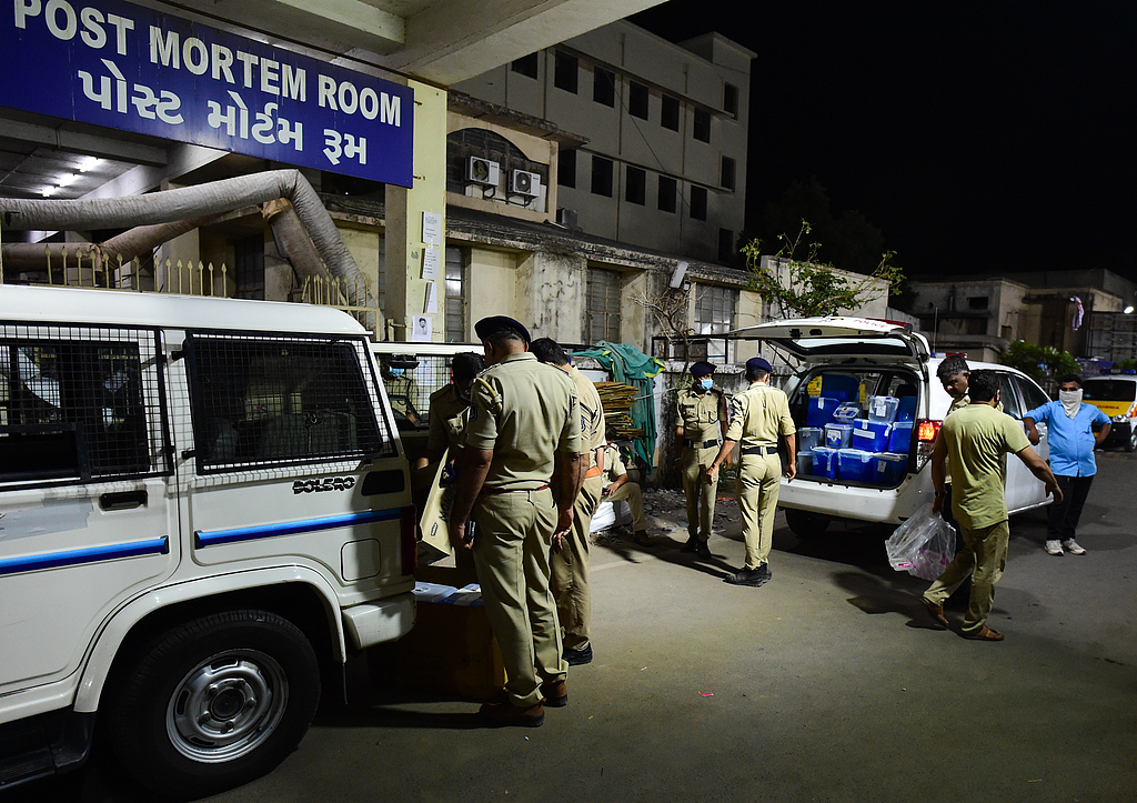 Police work the scene as a van holds boxes of remains of victims killed in the Air India flight that crashed shortly after takeoff, outside a morgue at the civil hospital, Ahmedabad, India, June 12, 2025. /CFP 
