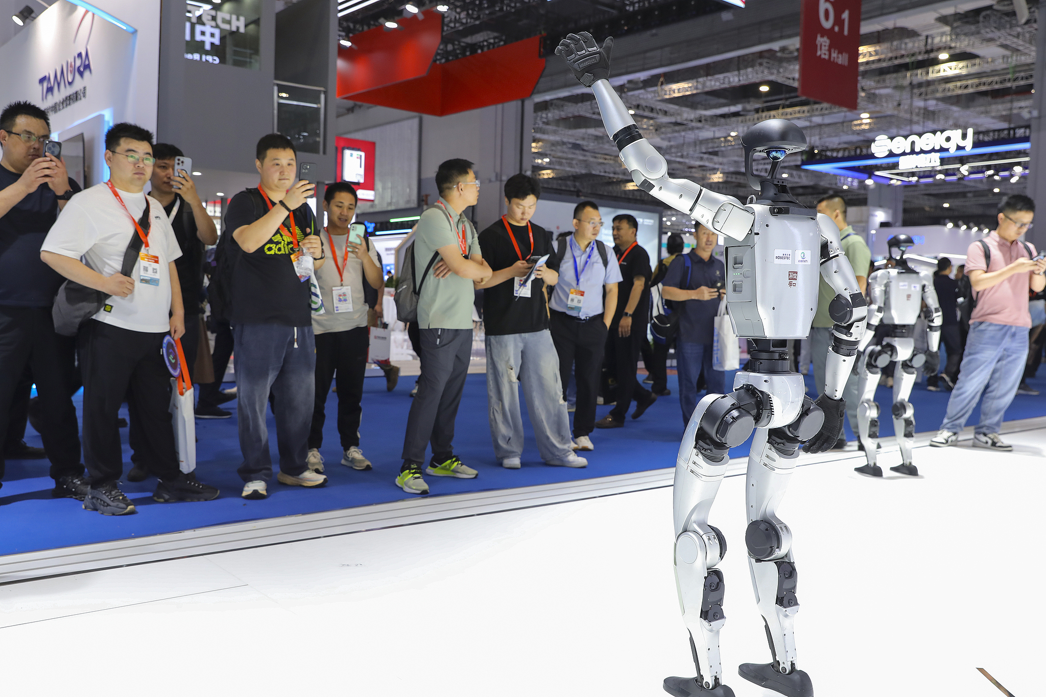 A humanoid robot from Unitree greets visitors at the SNEC Shanghai Solar Expo, China, June 12, 2025. /VCG