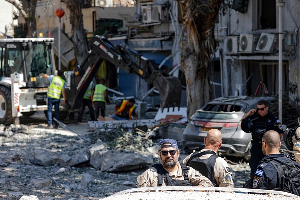 Israeli first responders and troops work in front of a building hit during an Iranian strike in the port city of Haifa, June 22, 2025. /VCG