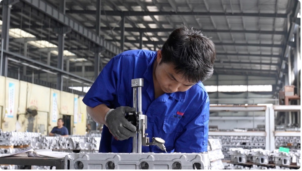 A worker at Nigo Intelligent Manufacturing is processing automotive parts, in Anqing City, Anhui Province, May 28, 2025. /CGTN