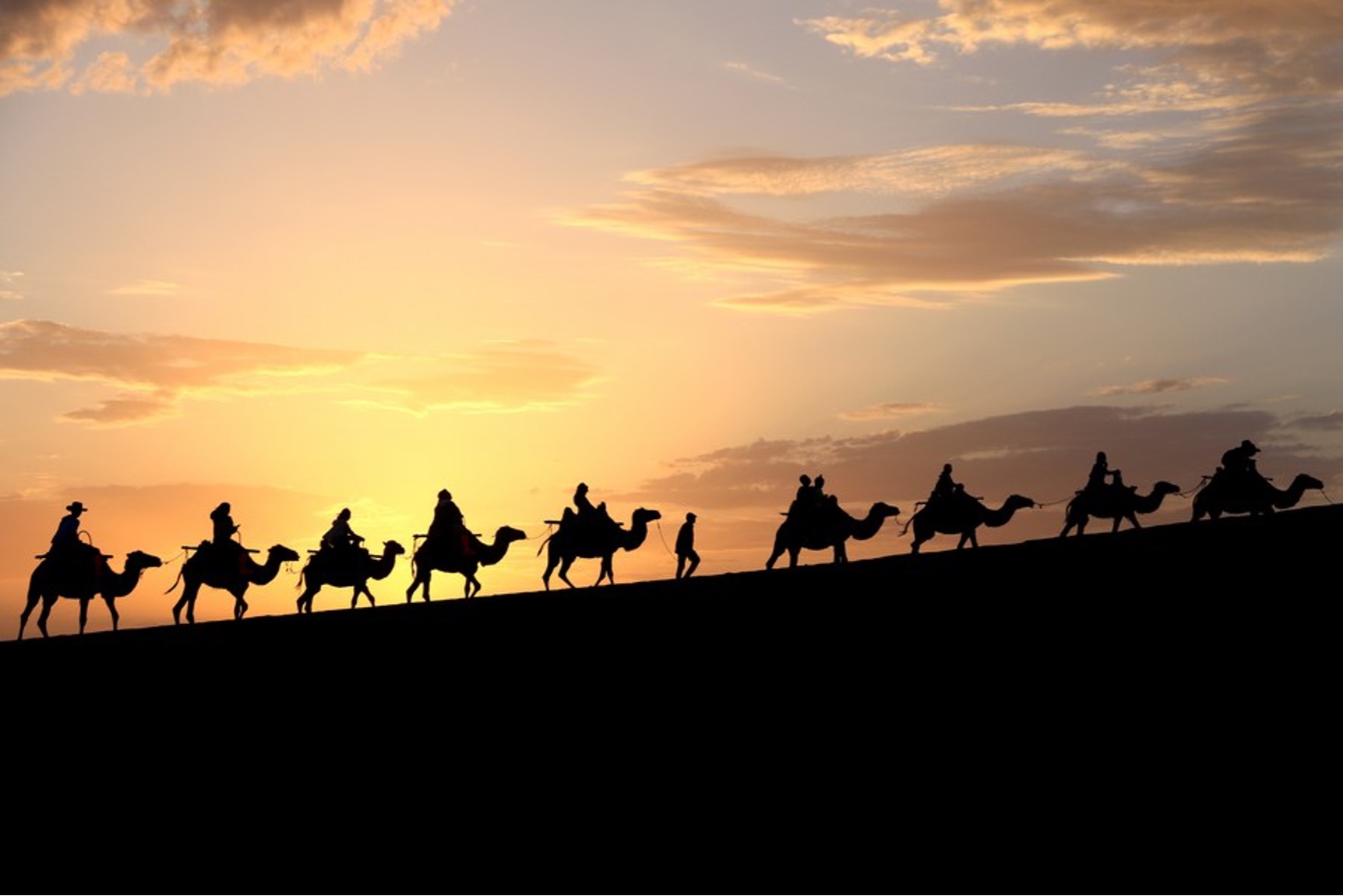 Tourists ride camels at the Mingsha Mountain and Crescent Spring scenic spot in Dunhuang, northwest China's Gansu Province, July 15, 2023. /Xinhua