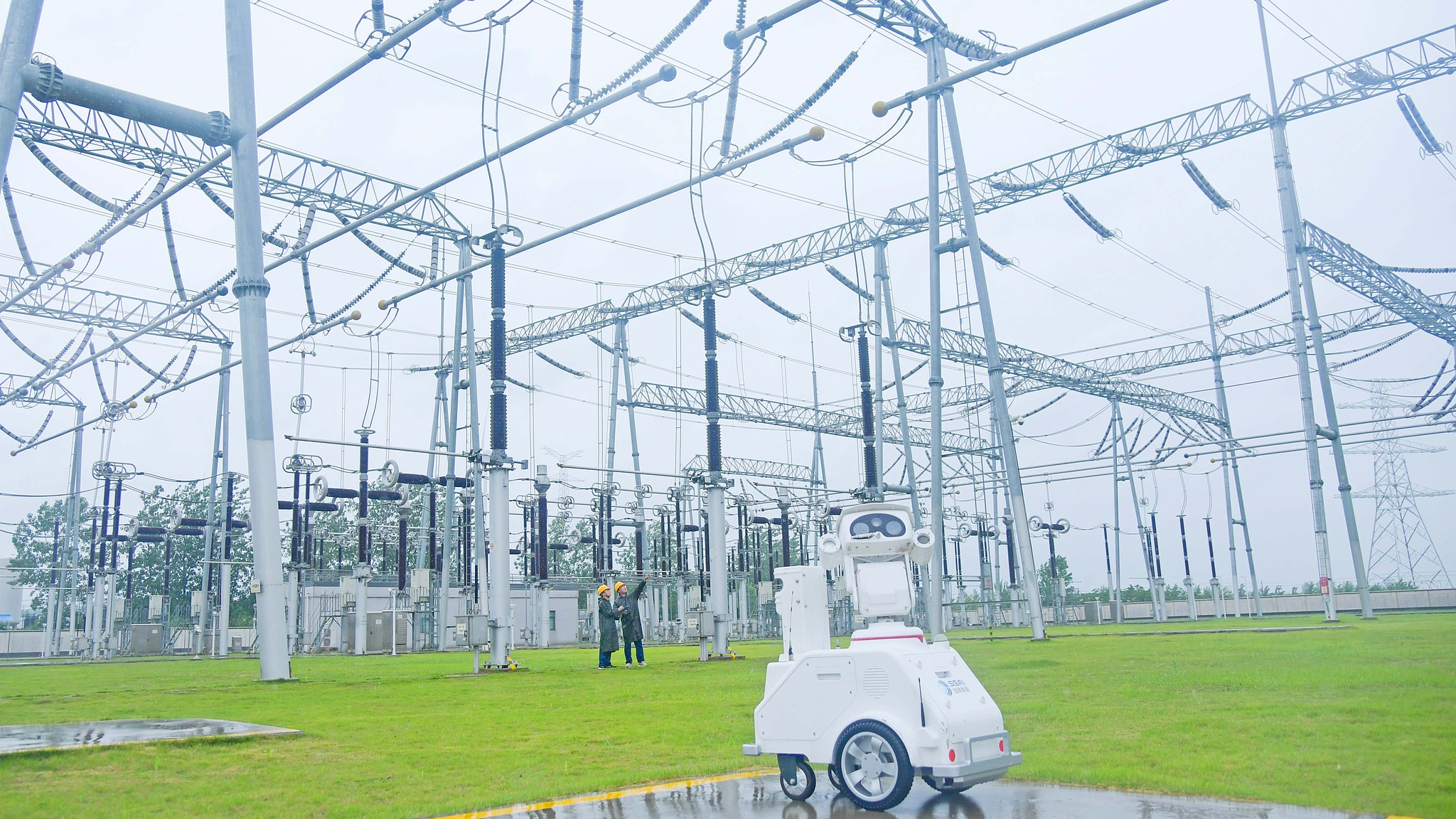 Power workers and a 5G intelligent inspection robot conduct a special inspection of the main equipment of a substation in Chuzhou City, east China's Anhui Province, June 20, 2025. /VCG