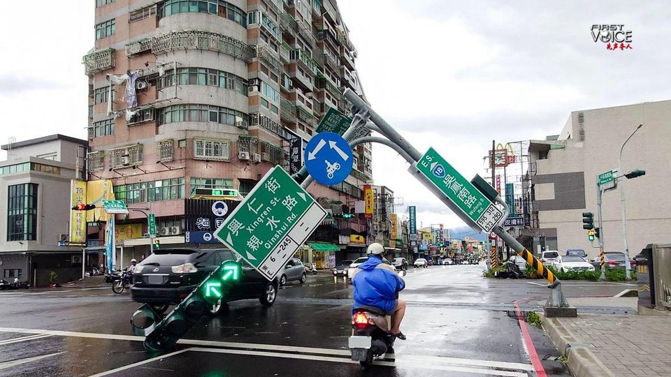 A man riding a scooter past traffic lights that were knocked down by typhoon Danas in Chiayi city in the Taiwan region, China, July 7. /AFP