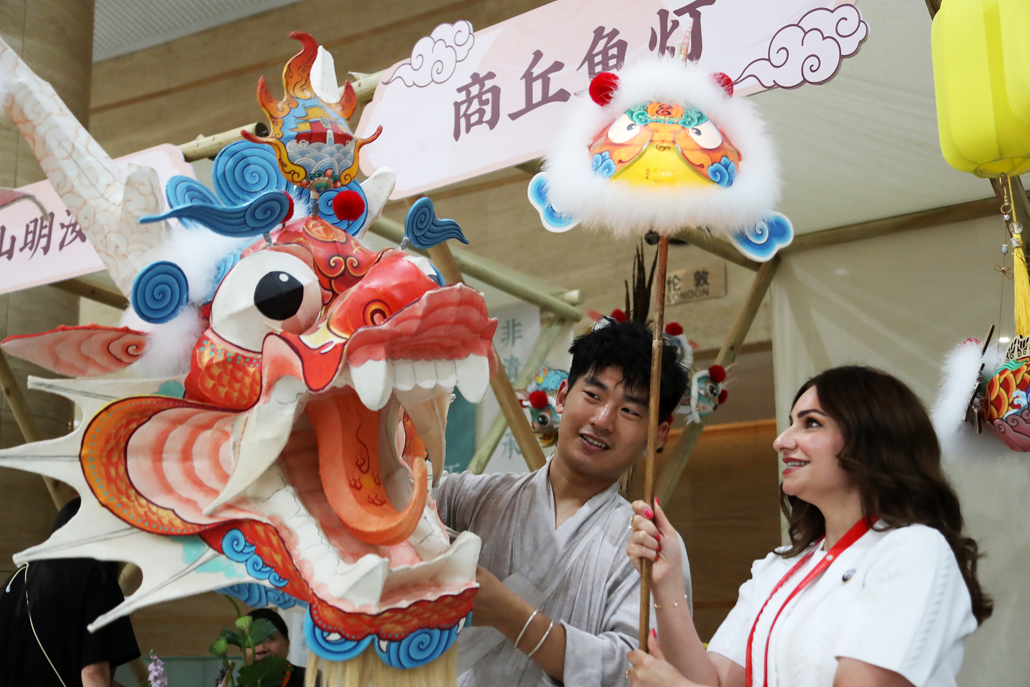 An attendee at the SCO Media and Think Tank Summit holds up a fish lantern at an exhibition in Zhengzhou, Henan Province, July 24, 2025. /VCG