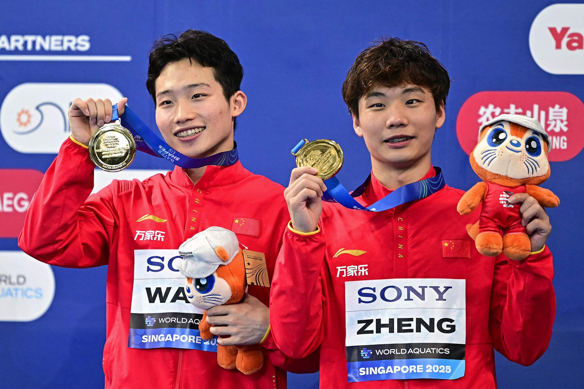 Gold medalists Wang Zongyuan (L) and Zheng Jiuyuan of China pose with their medals after winning the men's 3-meter synchronized diving springboard final at the World Aquatics Championships in Singapore, July 28, 2025. /VCG