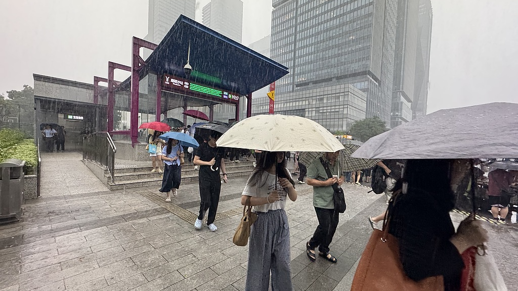 People in Guangzhou, south China's Guangdong Province, walk in the rain on the morning of August 6, 2025. /VCG