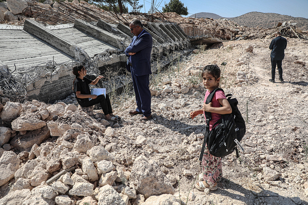 Palestinian students walk past the rubble of their school, which was demolished by Israeli forces in the village of Aqaba in the northern Jordan Valley in the occupied West Bank, Palestine, August 5, 2025. /VCG 