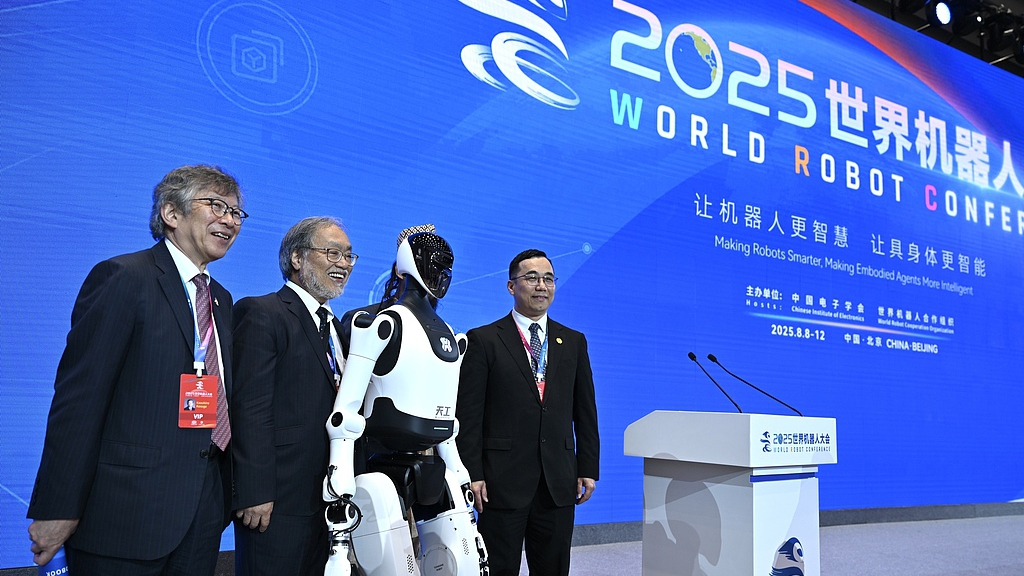 Guests take pictures with a humanoid robot at the World Robot Conference, Beijing, China, August 8, 2025. /VCG
