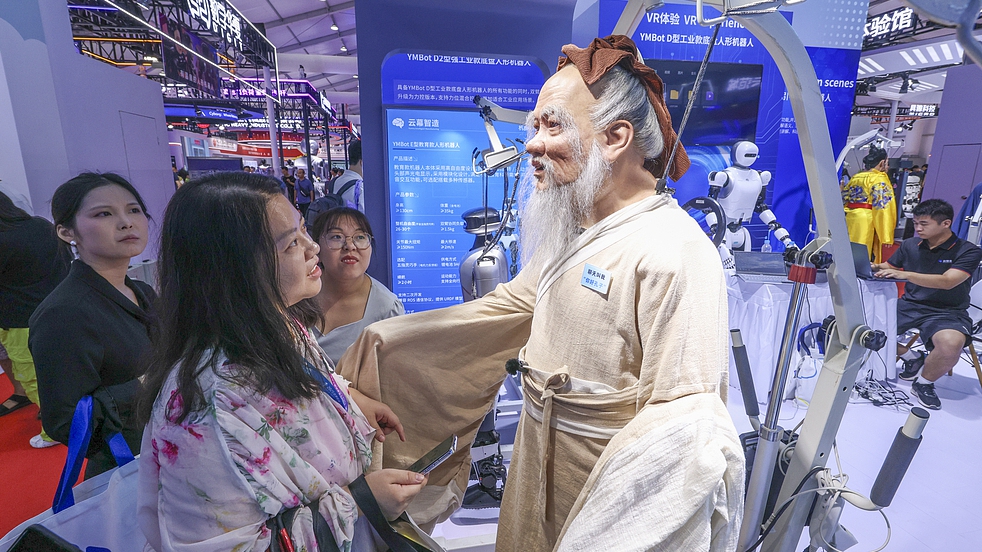 Visitors interact with a humanoid robot at the World Robot Conference, Beijing, China, August 8, 2025. /VCG