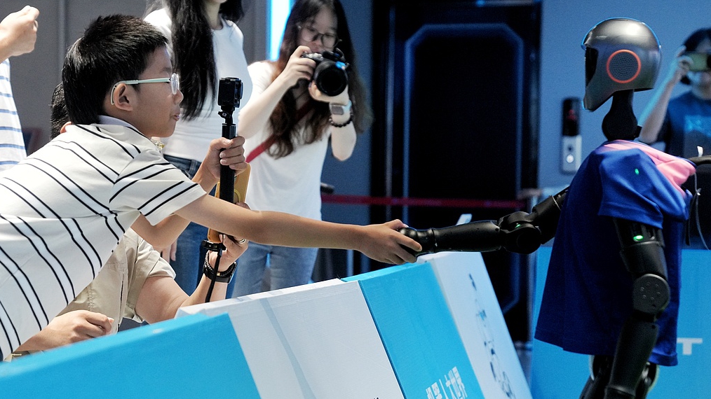 A child shakes hands with a humanoid robot at the World Robot Conference, Beijing, China, August 8, 2025. /VCG