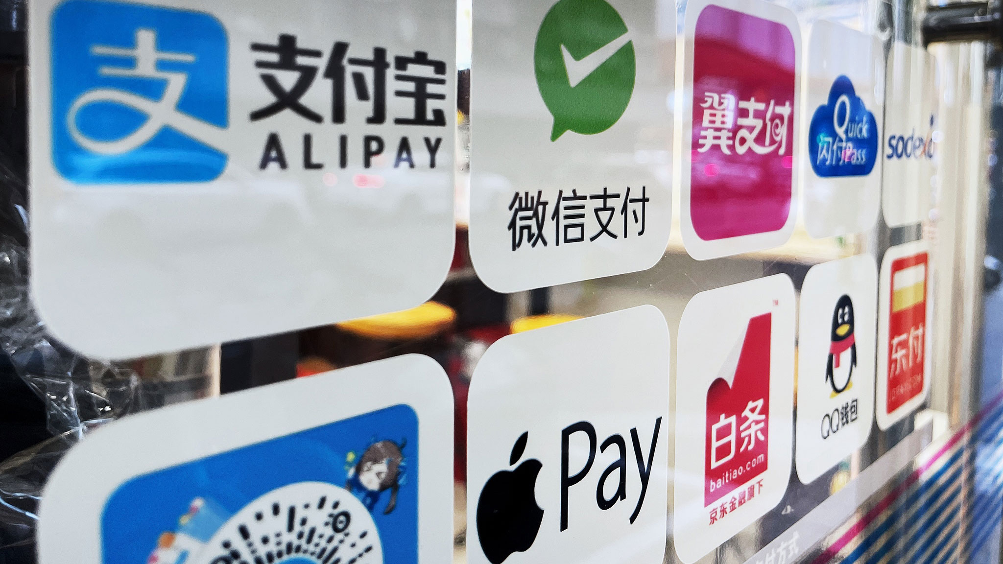 Apple Pay's logo is seen among competitors' logos on a door of a convenient store in Nanjing City, east China's Jiangsu Province, June 30, 2023. /VCG