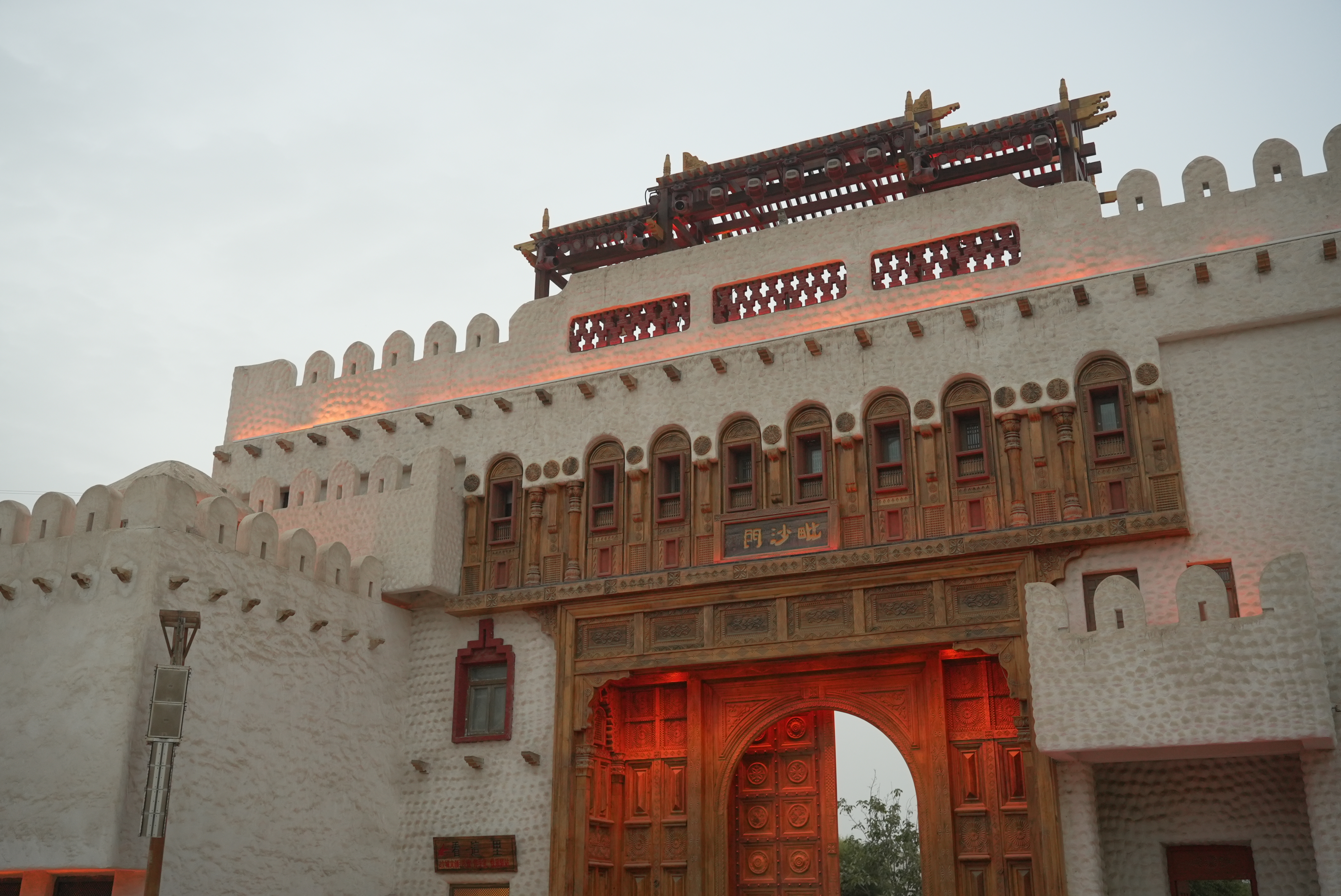 The gate of Yotkan Ancient City in Hotan glows under warm lights, exuding timeless charm and reflecting the historic style of the Western Regions. 