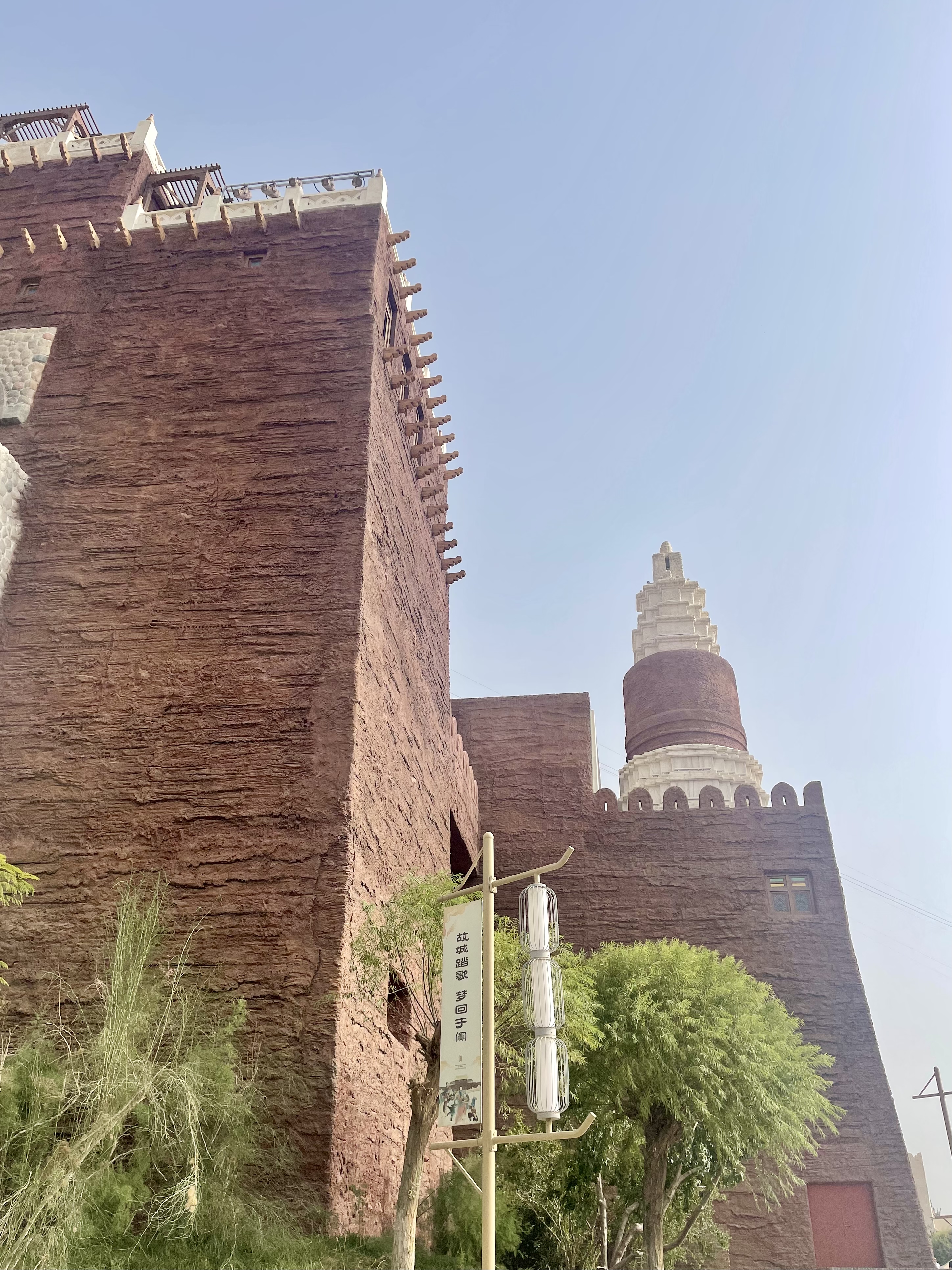 Red walls, green trees, and a stupa form a unique tableau where history blends seamlessly with nature in Yotkan Ancient City, northwest China's Xinjiang Uygur Autonomous Region. 