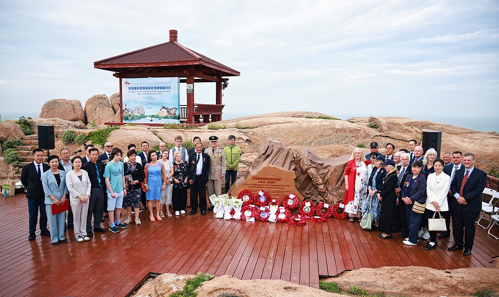 A monument commemorating the Dongji fishermen's rescue of 384 British POWs is unveiled on Dongji Island in Zhoushan, Zhejiang Province, May 20, 2025. The ceremony was witnessed by 18 descendants of the British prisoners from the Lisbon Maru shipwreck who traveled all the way from the UK to China. /VCG