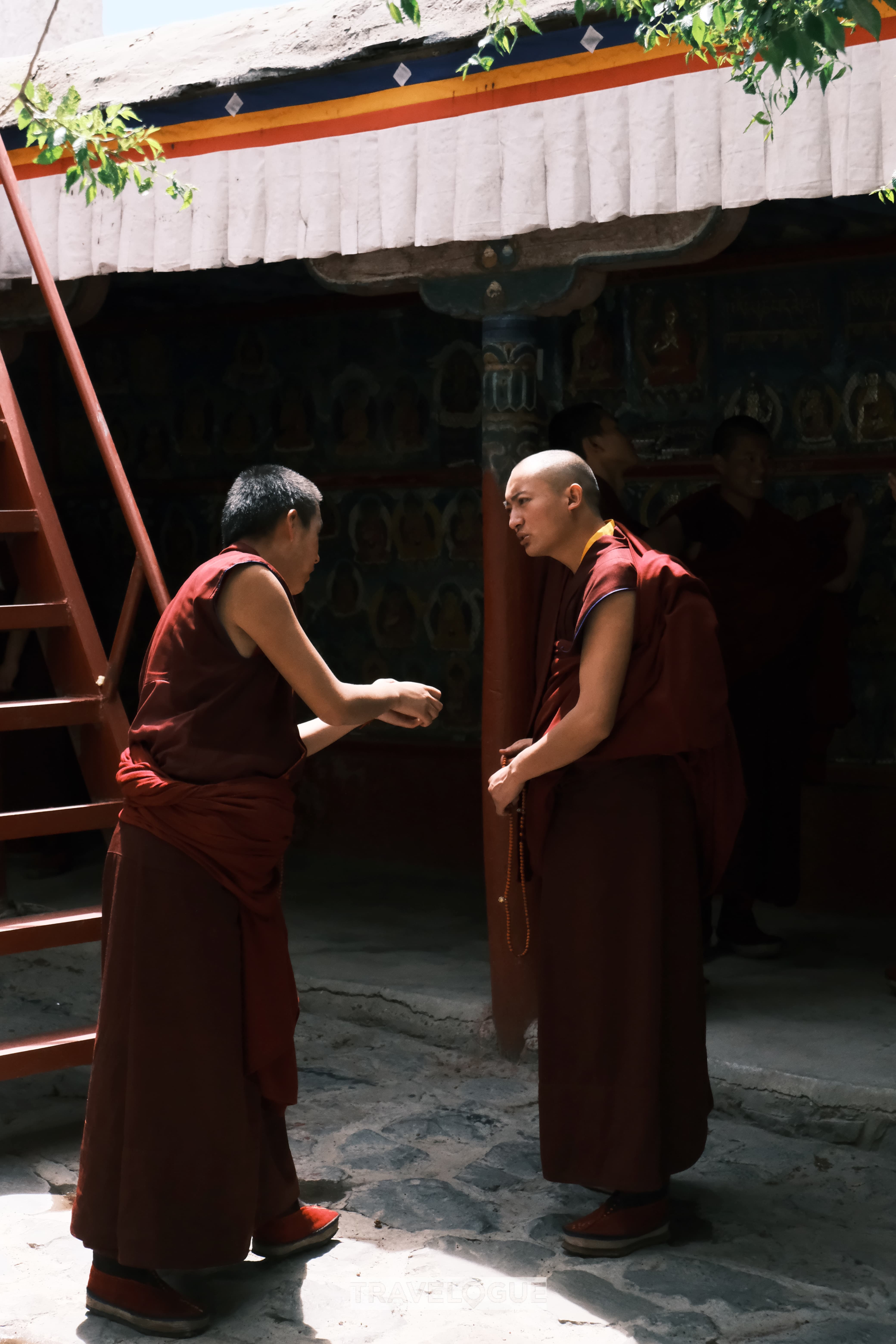 Two monks talk at Tashilhunpo Monastery. /CGTN