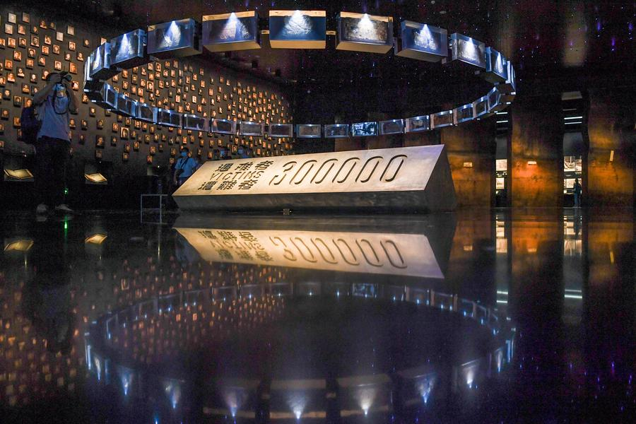 A reporter takes photos at the Memorial Hall of the Victims in Nanjing Massacre by Japanese Invaders in Nanjing, capital of east China's Jiangsu Province, September 18, 2021. /Xinhua