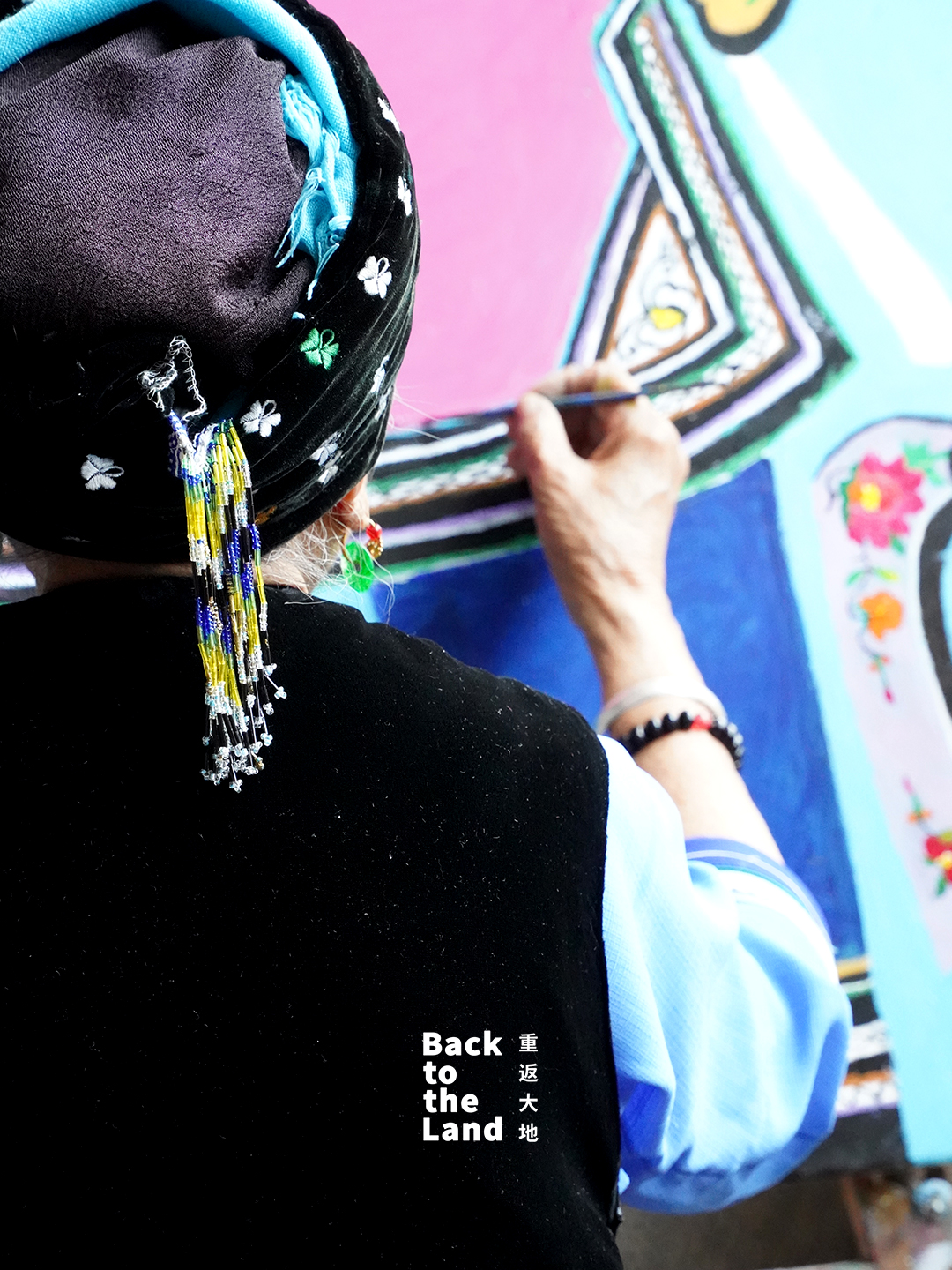 An elderly Bai ethnic woman uses pigments from local soils and embroidery-inspired brushstrokes to create paintings in Dali, southwest China's Yunnan Province. /CGTN