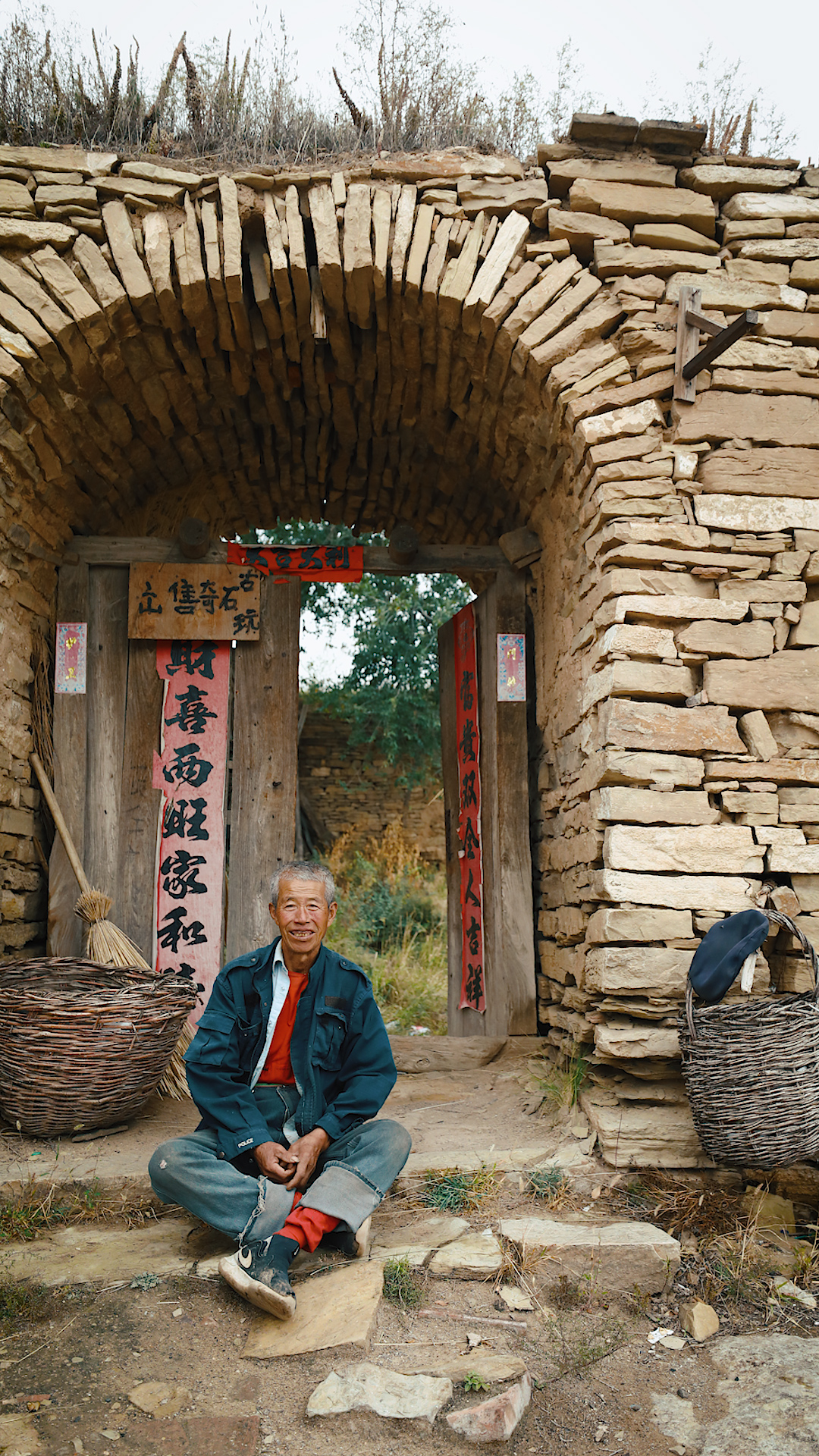 A villager sits in front of his home in the Laoniuwan Fortress. Before 2000, the local villagers earned a living working as migrant laborers in the city. Now, with the development of rural tourism, Laoniuwan is attracting an increasing number of visitors. At the time this photo was taken, all the villagers had moved out of the fortress except for one old man. /CGTN