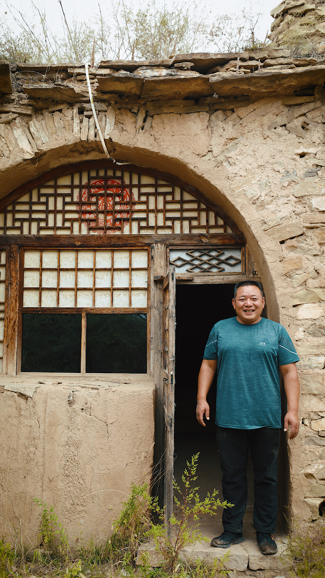 Villager Guo Shuaisheng visits his old home in the Laoniuwan Fortress. /CGTN