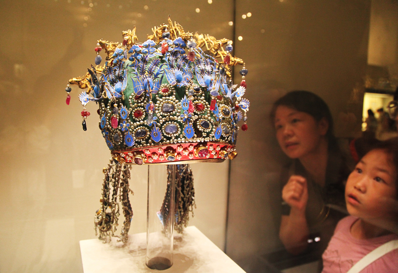 Visitors admire the Phoenix Coronet for Empress Xiaoduan on display at the National Museum of China in Beijing. /CGTN
