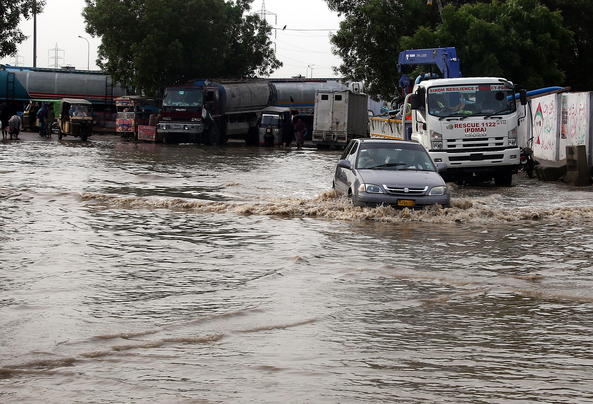 People make their way through a water-logged road after heavy rainfall in Karachi, Pakistan, August 20, 2025. /VCG