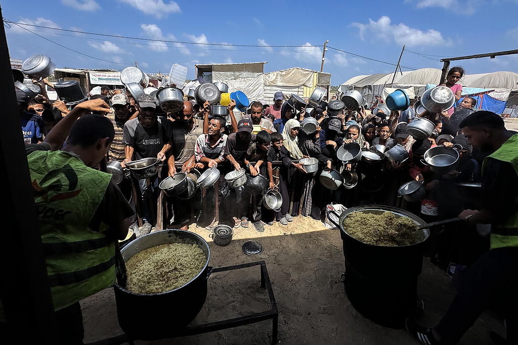 Palestinians wait to receive food from a charity kitchen amid a hunger crisis in Khan Yunis, Gaza, August 21, 2025. /VCG