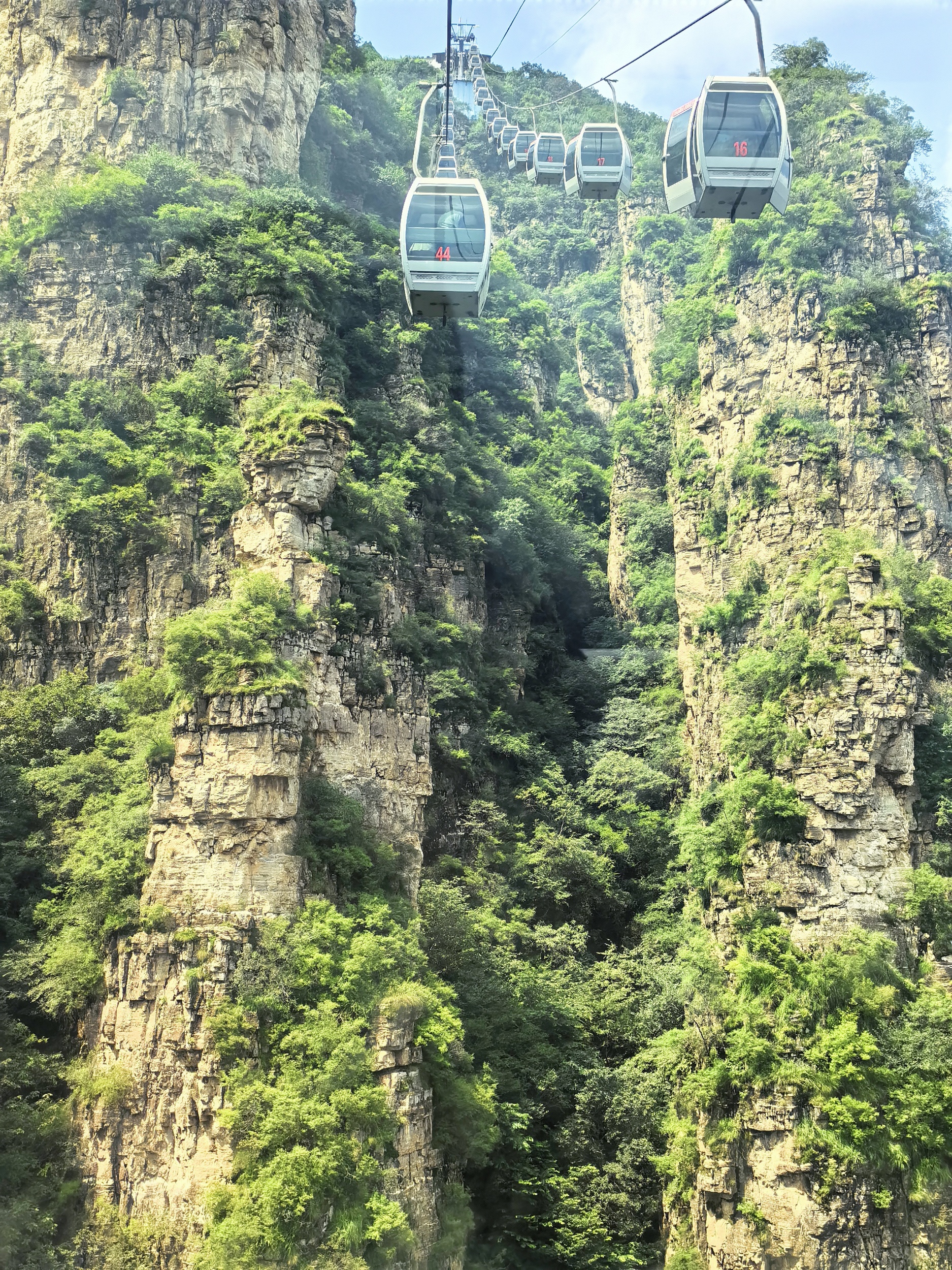Tourists take the cable car to tour Langya Mountain in Yixian County, north China's Hebei Province on August 17, 2025. /CGTN