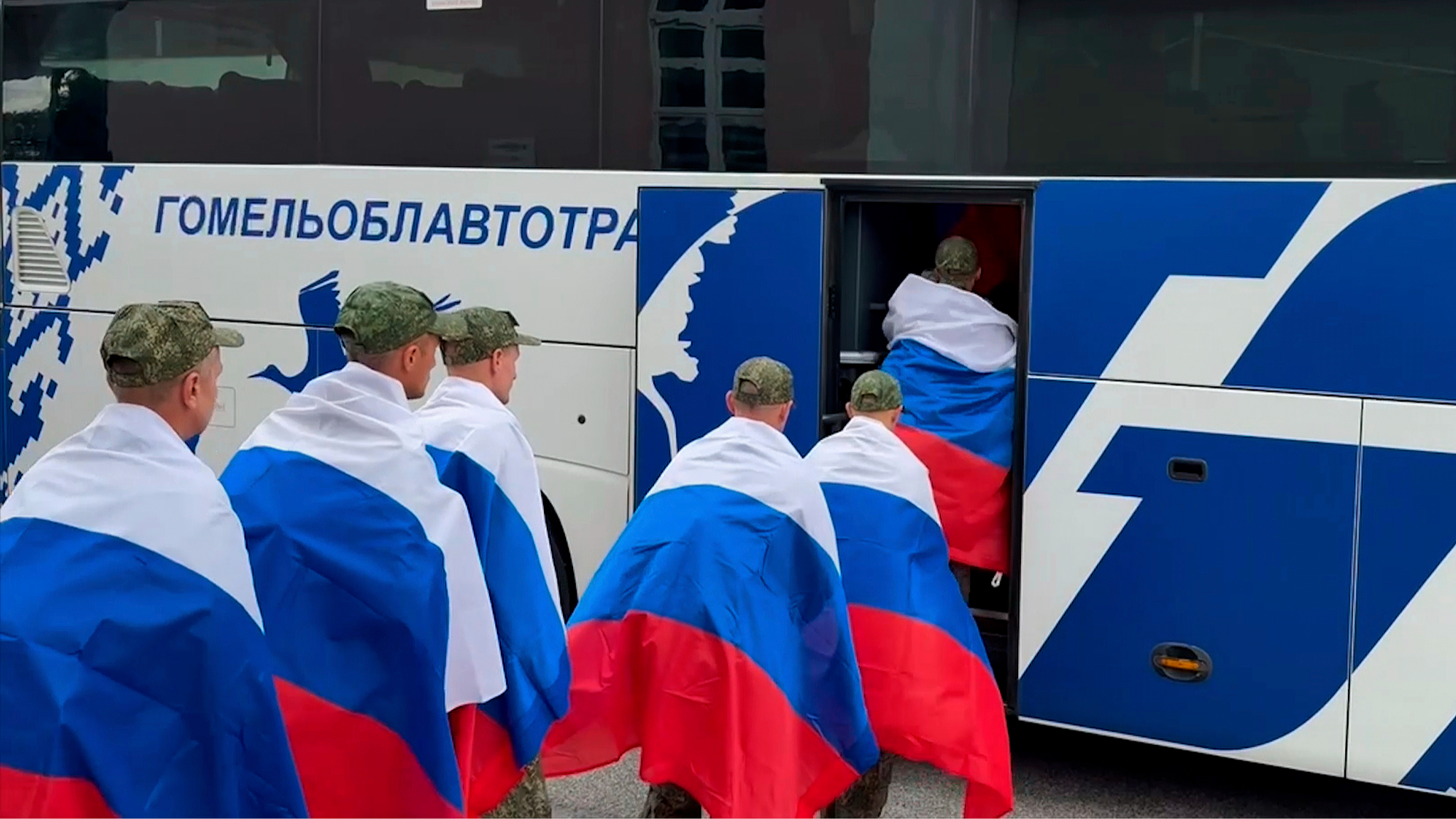 In this still taken from a video and distributed by the Russian Defense Ministry Press Service on August 24, 2025, Russian servicemen with Russian national flags line up to board a bus at an exchange area in Belarus following a prisoner exchange involving a group of servicemen between Russia and Ukraine. /VCG