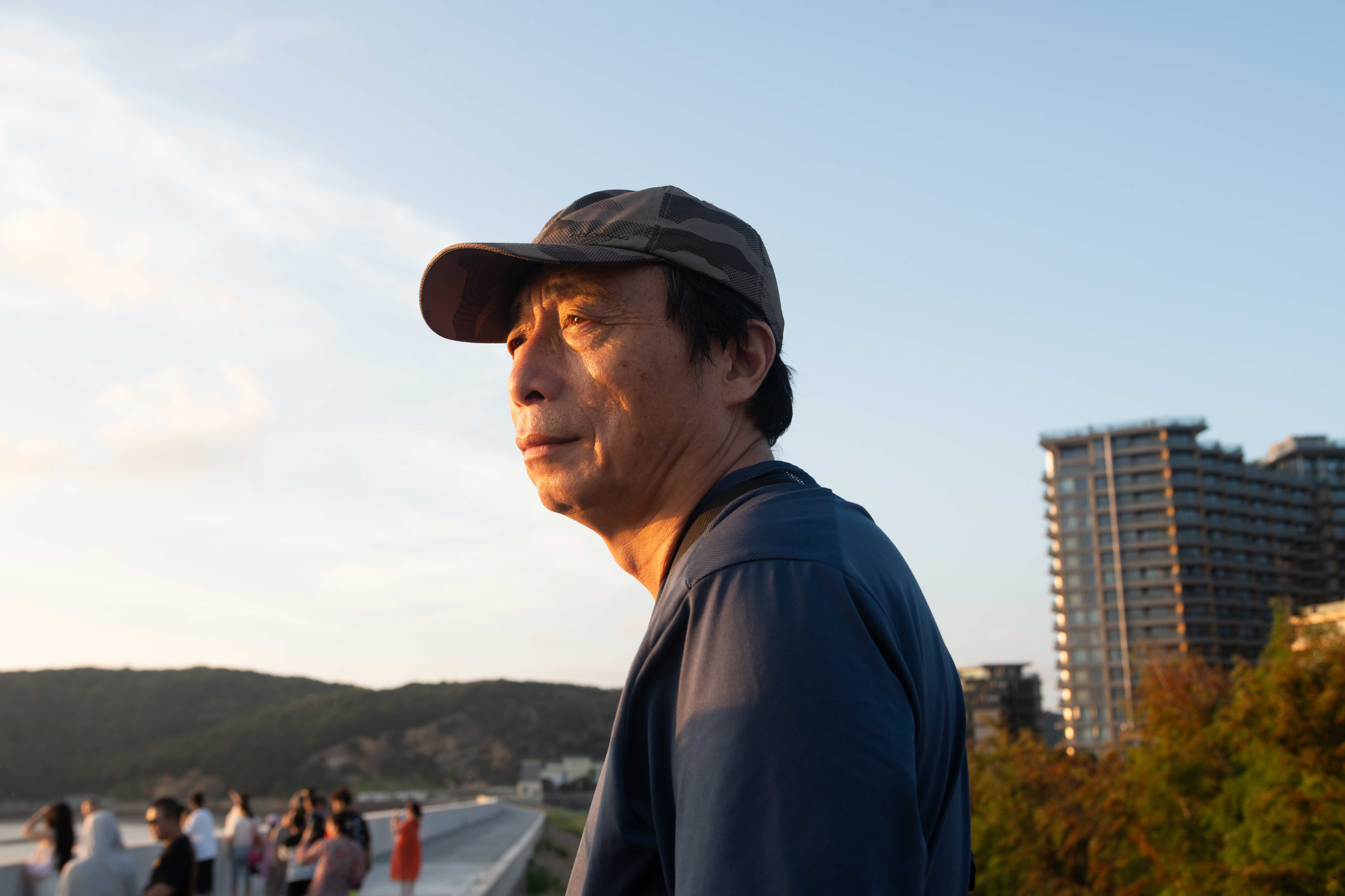 Old Man: At a corner of the seawall, my attention was drawn to an old man. As the setting sun slowly shone down, he gazed in the direction of the setting sun. The unyielding spirit of the Chinese people, China's long history, personal beliefs, and the accumulation of Chinese culture have all settled in him and ultimately converged in those deep eyes. This look is heavier than an anchor, inspiring awe. What it carries is not just the weight of the years, but also reflects the continuation and perseverance of culture and society. It is the countless people like him who quietly contribute, allowing knowledge, beliefs, and values to flow in the community and enabling civilization to be passed on. Every act of guardianship and dedication quietly pushes society forward in a more inclusive and sustainable direction. /Chi Yuchen