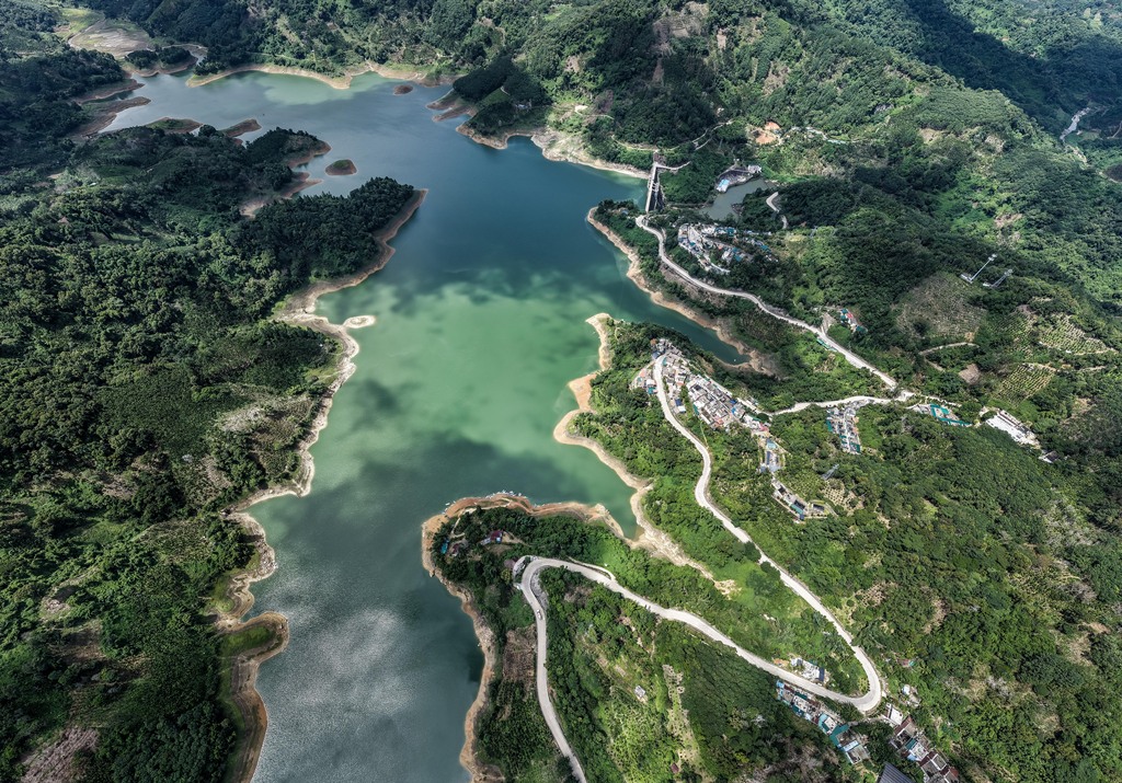 A photo shows the lush greenery surrounding a reservoir in Wuzhishan City, Hainan Province, on August 19, 2025. /VCG