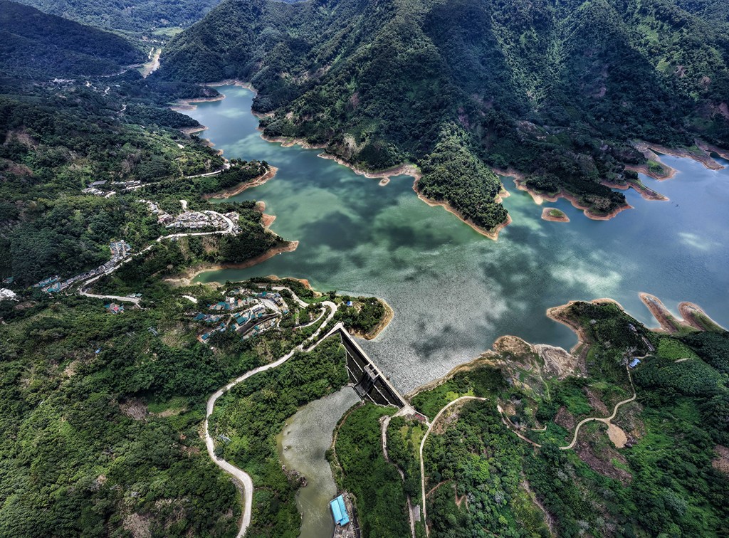 A photo shows the lush greenery surrounding a reservoir in Wuzhishan City, Hainan Province, on August 19, 2025. /VCG