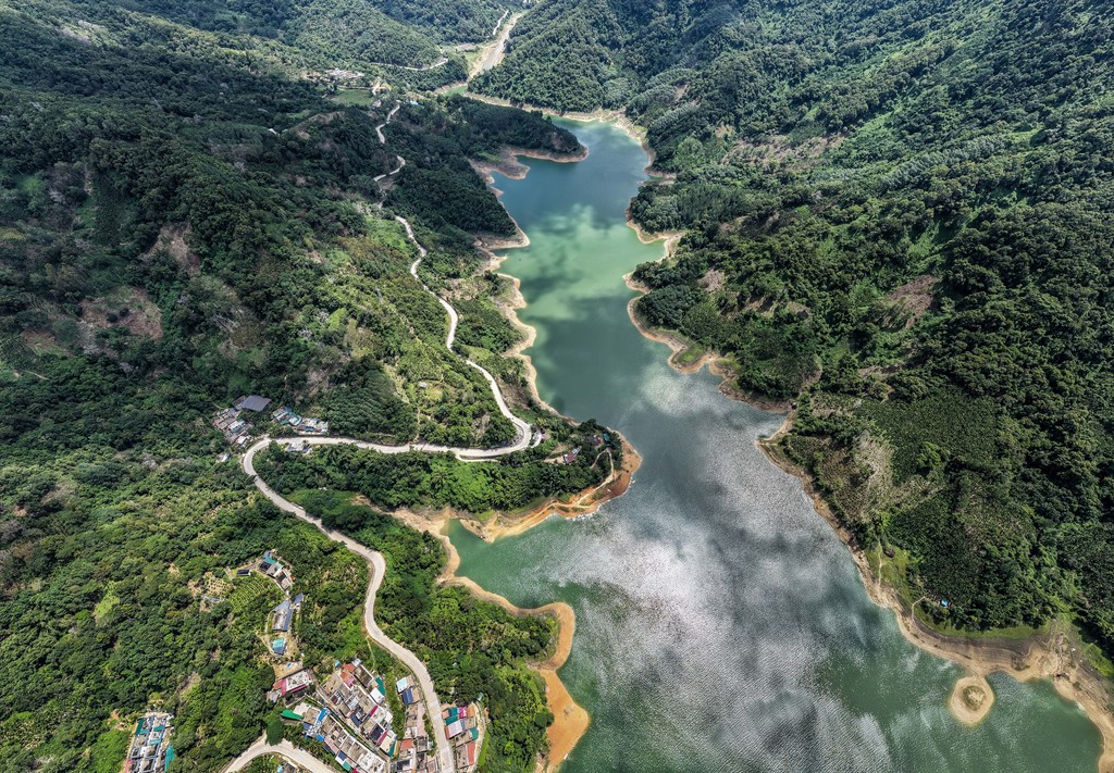 A photo shows the lush greenery surrounding a reservoir in Wuzhishan City, Hainan Province, on August 19, 2025. /VCG