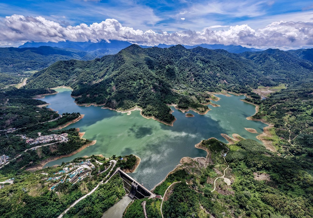 A photo shows the lush greenery surrounding a reservoir in Wuzhishan City, Hainan Province, on August 19, 2025. /VCG