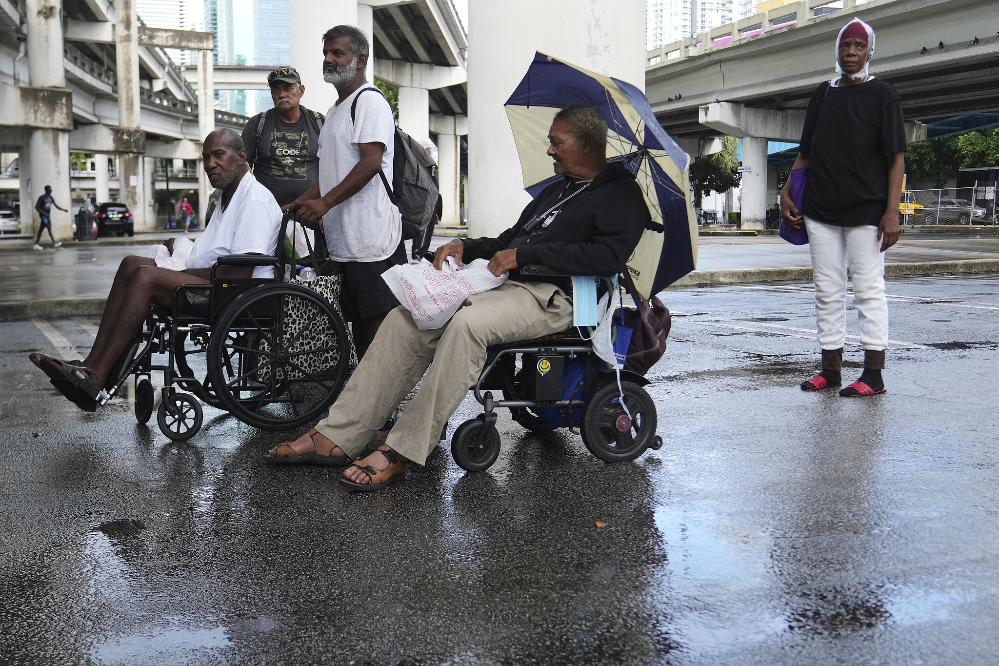 People seen waiting in line for a free hot meal offered by the One World One Heart organization, August 21, 2025, in downtown Miami. /VCG
