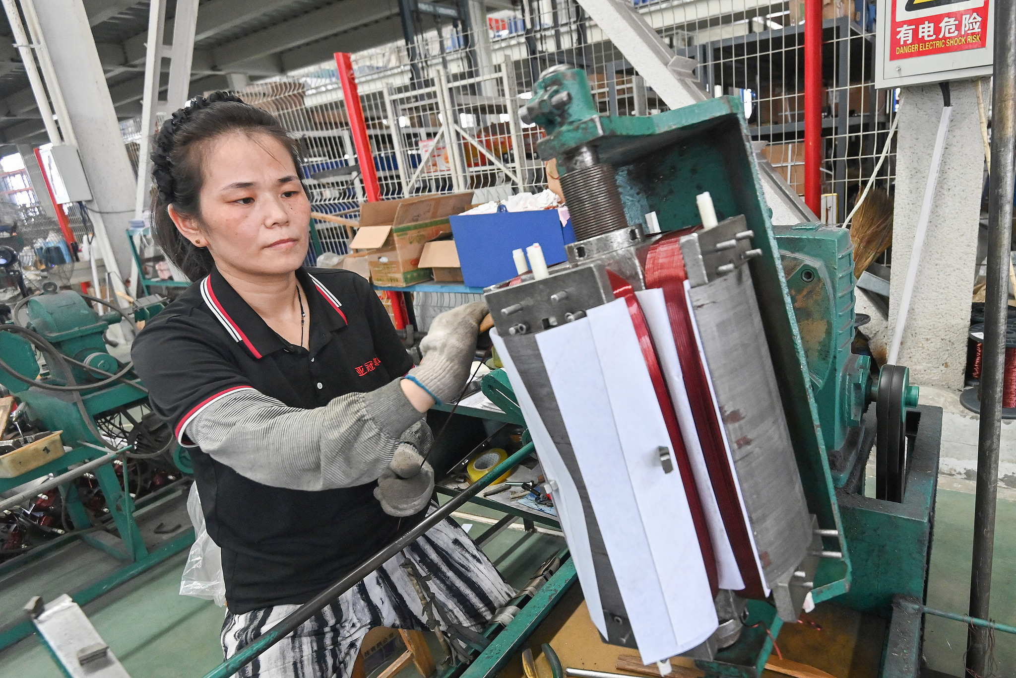 A worker at a generator manufacturing enterprise seen assembling and producing in a workshop at Qingzhou, Shandong Province, August 31. /VCG photo