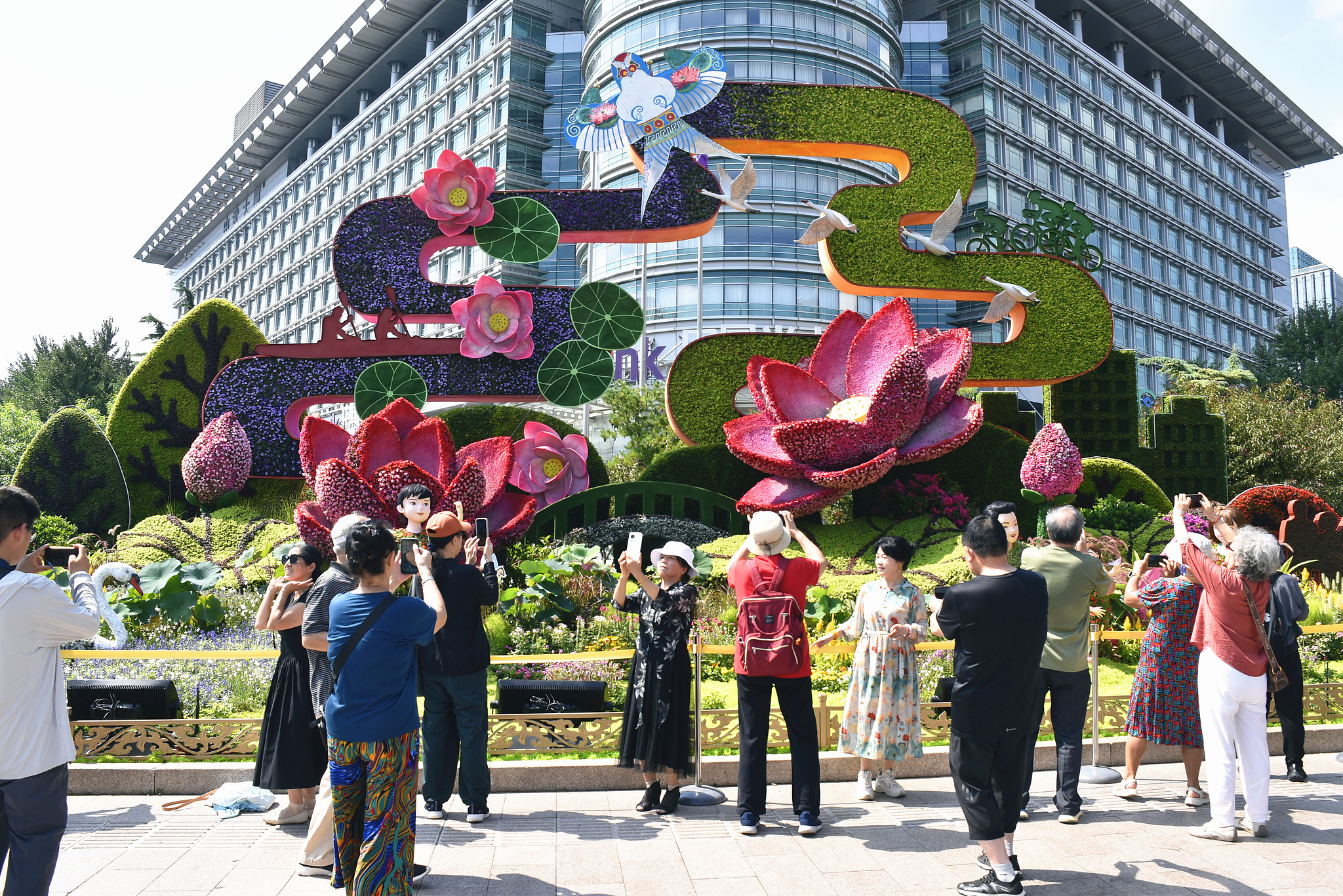 Take photos of a floral installation for the commemoration event marking the 80th anniversary of the victory of the Chinese People's War of Resistance Against Japanese Aggression and the World Anti-Fascist War, in Beijing, August 31, 2025. /VCG