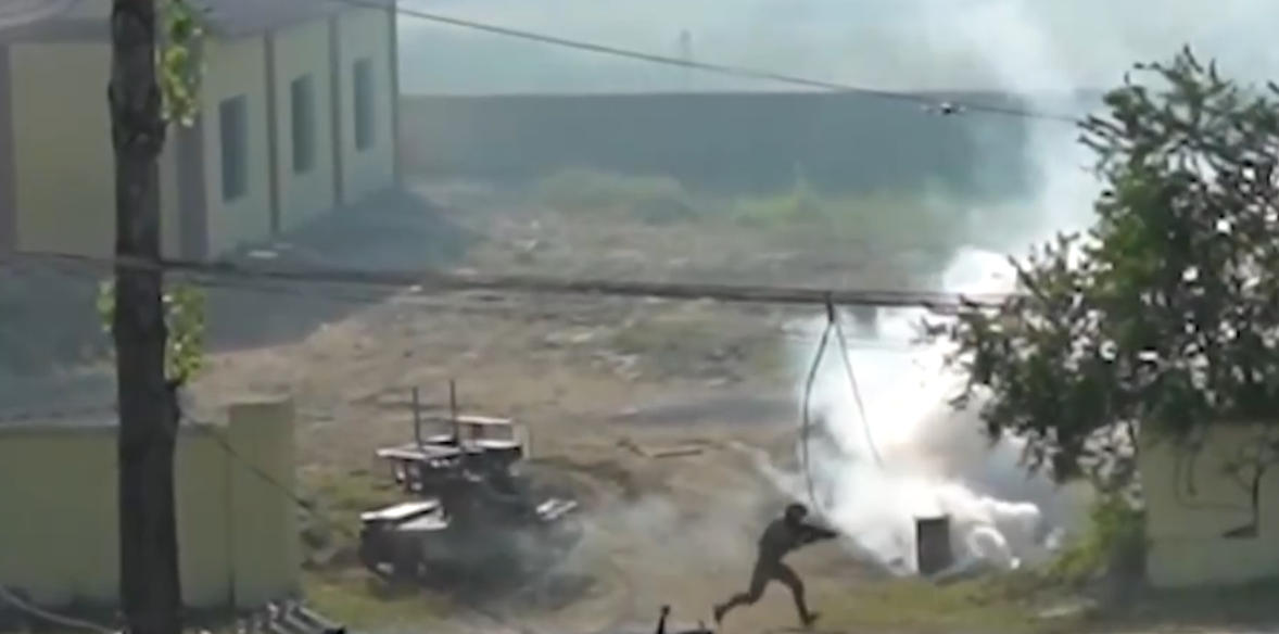 A screenshot from footage capturing a Chinese soldier and an unmanned vehicle work together during a military drill. /CMG