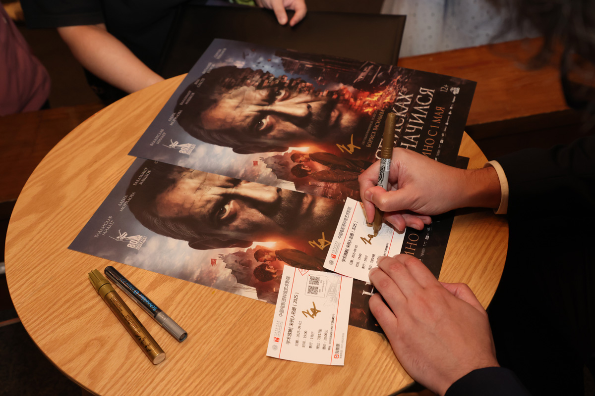 Signatures are made on both the tickets and posters for a Russian film screening at the Russian Film Festival which runs until September 12, 2025 in three Chinese cities. /Photo provided to CGTN